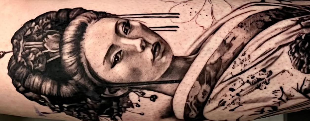 Tattoo of a geisha on a person's arm with a neutral background